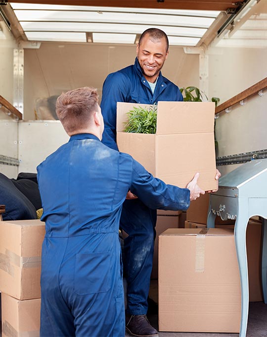 movers handing eachother boxes in moving truck